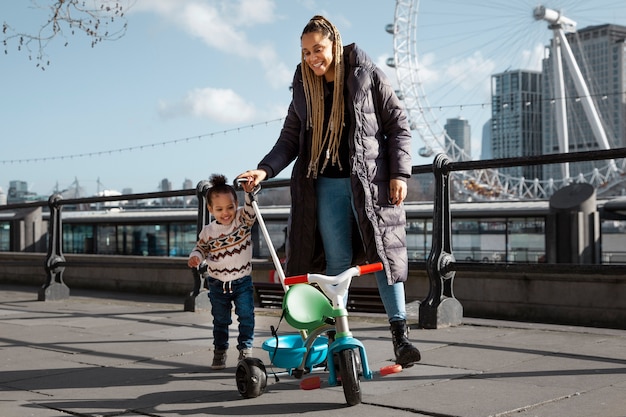 Full shot smiley woman walking with kid