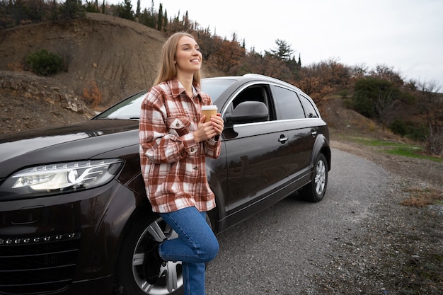 コーヒーカップとフルショットのスマイリー女性