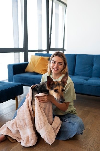 Foto gratuita donna sorridente del colpo pieno con il cane sveglio