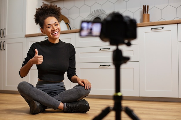 Foto gratuita donna sorridente del colpo pieno con la videocamera