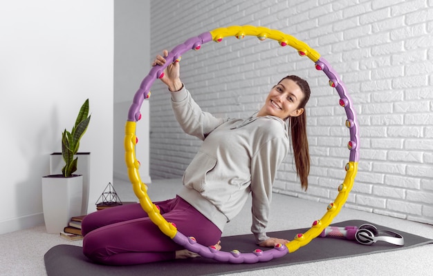 Donna piena di smiley del colpo sulla stuoia di yoga