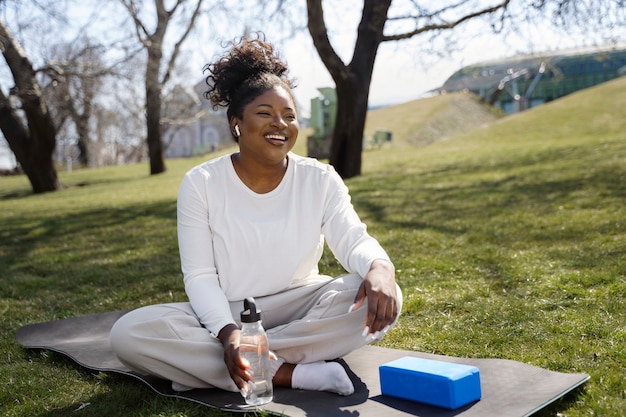 Full shot smiley woman on yoga mat