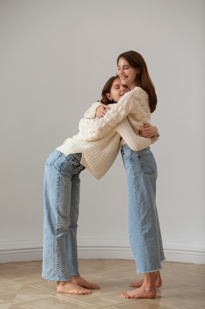 Foto gratuita donne sorridenti del colpo pieno che si abbracciano in studio