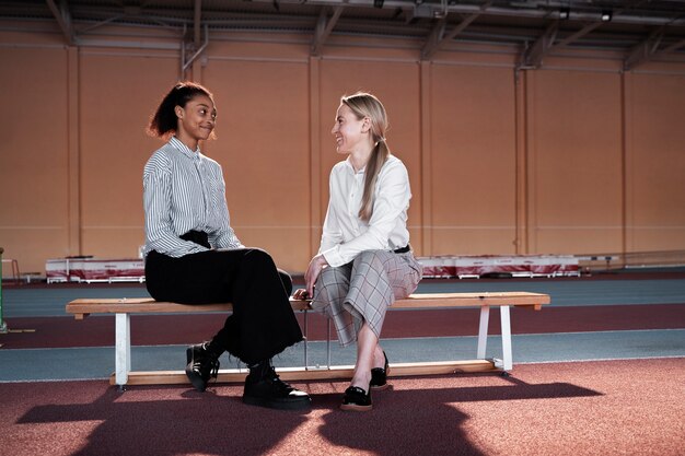 Full shot smiley women sitting on bench