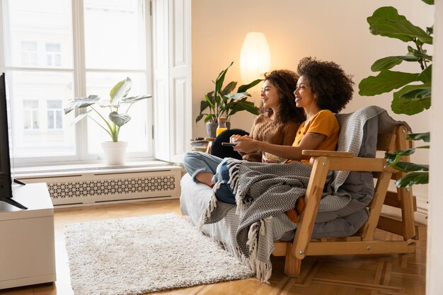 Full shot smiley women sitting on couch