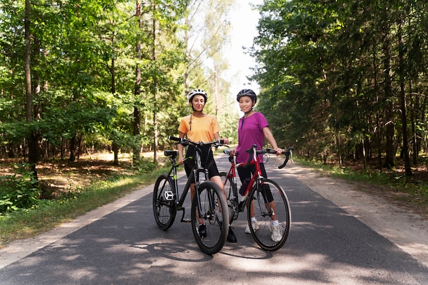 Free photo full shot smiley women with bicycles