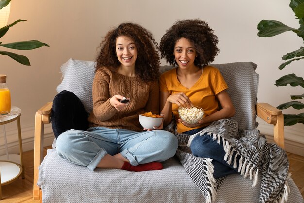 Full shot smiley women with remote