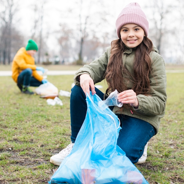 Full shot of smiling girl recycling