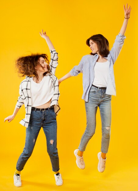 Full shot of smiling women jumping