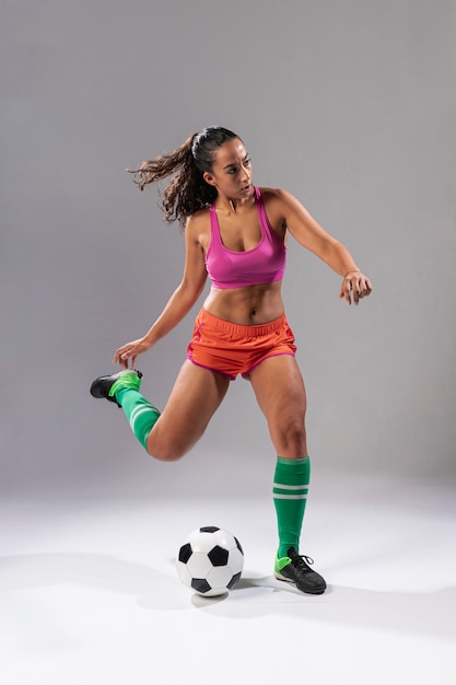 Full shot soccer woman пиная мяч