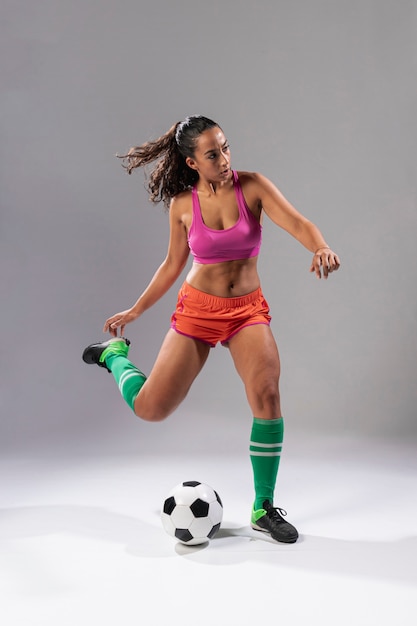Full shot soccer woman kicking ball