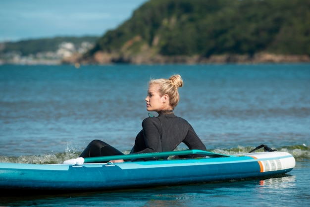 Full shot sportswoman paddleboarding