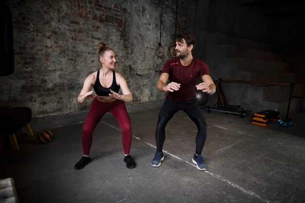 Full shot sporty people doing exercises indoors