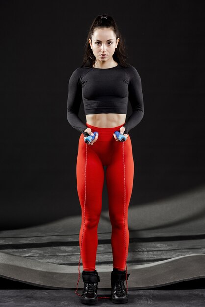 full shot of sporty woman with jumping rope