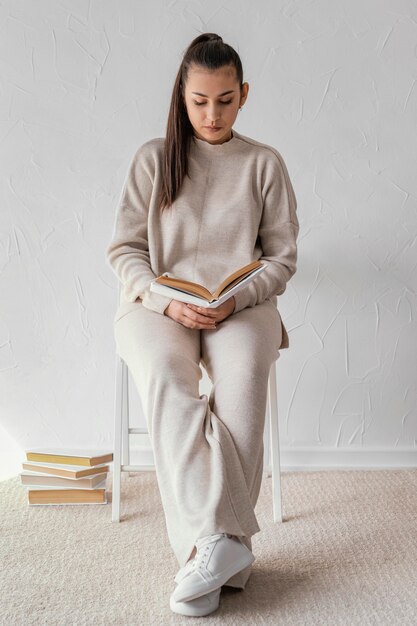 Full shot student reading  on chair