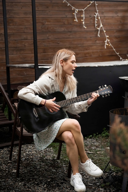 Donna di talento a tutto campo che suona la chitarra