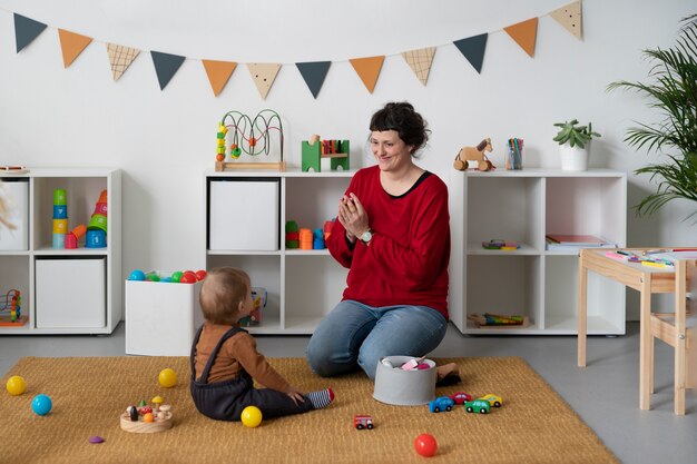 Full shot teacher helping cute kid