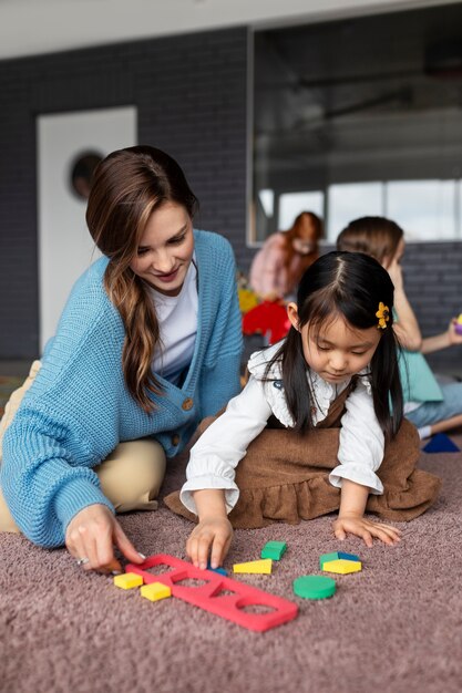 Full shot teacher helping girl learn