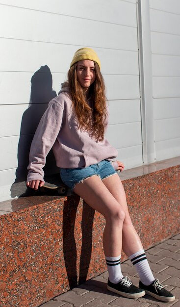 full shot teen girl sitting outdoors