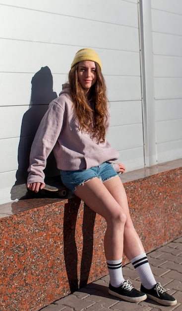 Full shot teen girl sitting outdoors