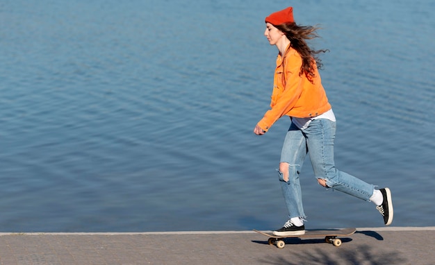 湖のそばのスケートでフルショットの十代の少女