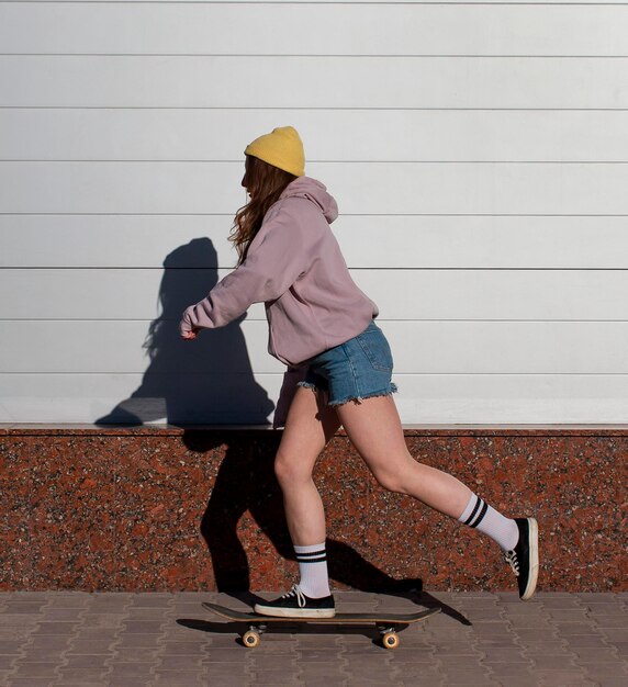 Full shot teen girl skating outdoors