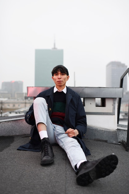 Free photo full shot teenager sitting on roof