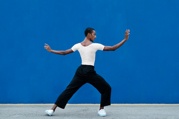 Full shot transgender dancing with blue background