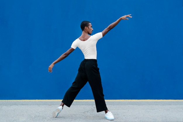 Full shot transgender dancing with blue background