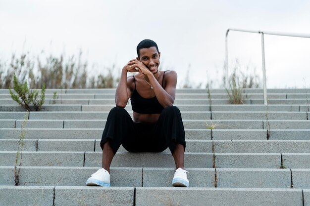 Full shot transgender sitting on stairs