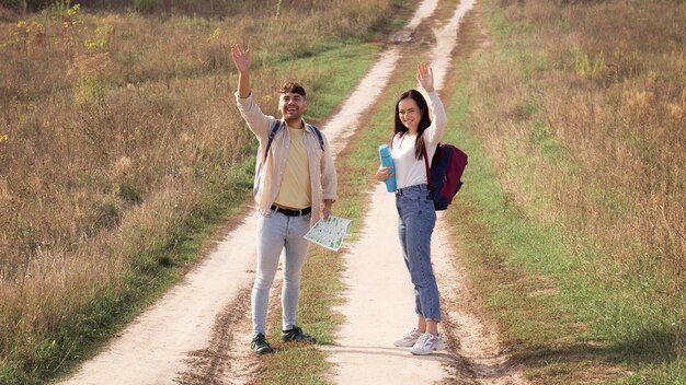 Foto gratuita viaggiatori full shot su strada di campagna