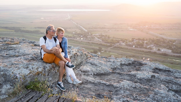 Free photo full shot traveling couple sitting