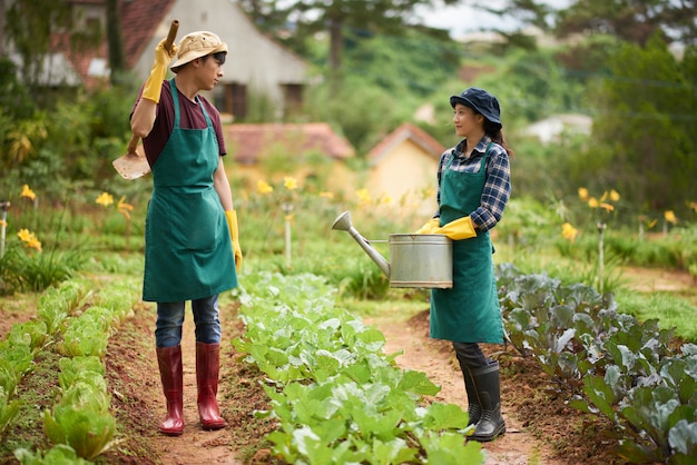 Full shot of two farmers having a chat in the middle of the garden