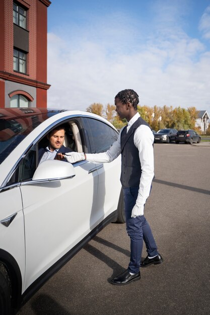 Full shot valet helping man