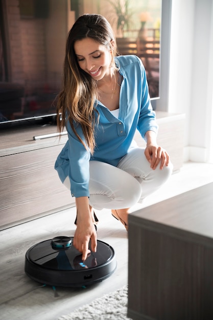 Full shot woman activating vacuum cleaner