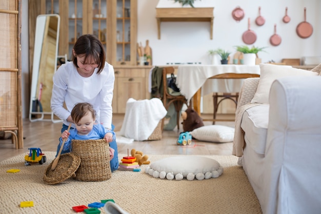 Full shot woman and baby in living room