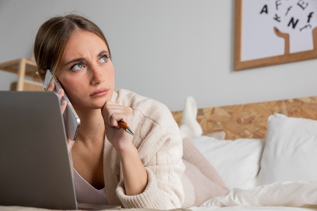 Full shot woman in bed with laptop