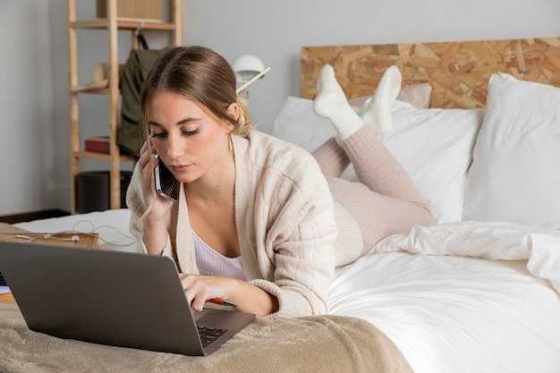 Foto gratuita donna piena del colpo a letto che lavora