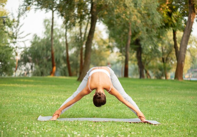 Full shot woman bending over in nature