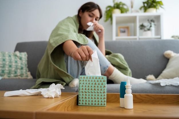 Full shot woman blowing nose