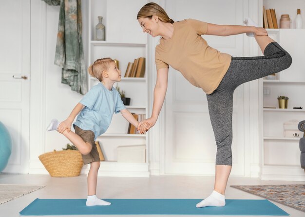 一緒に運動するフルショットの女性と少年