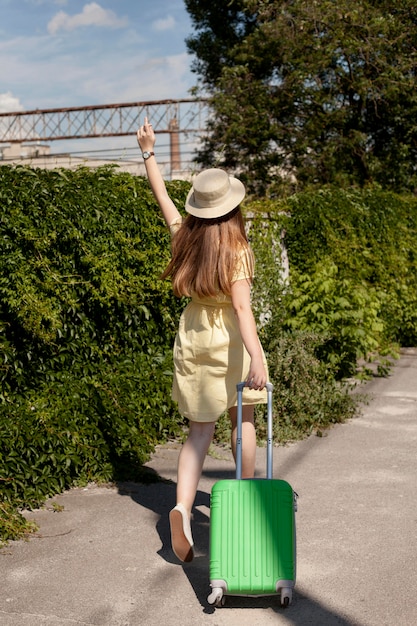 緑の荷物を運ぶフルショットの女性