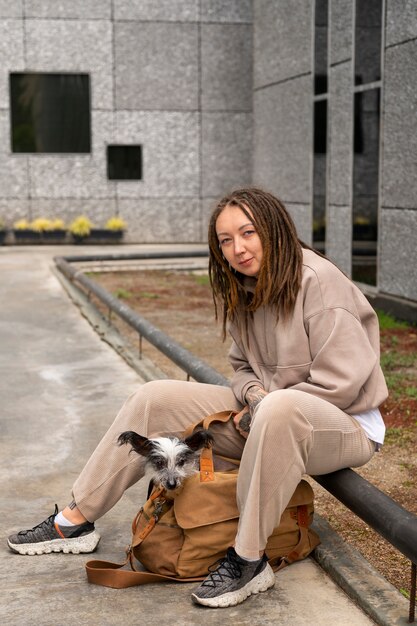 Full shot woman carrying puppy in bag