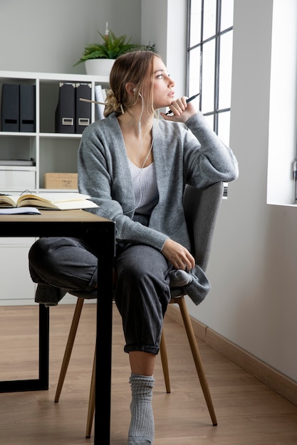 Full shot woman on chair thinking