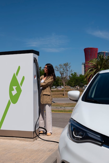 Full shot woman charging electric car