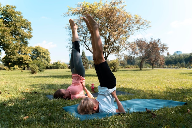 Donna e bambino a tutto campo che fanno yoga