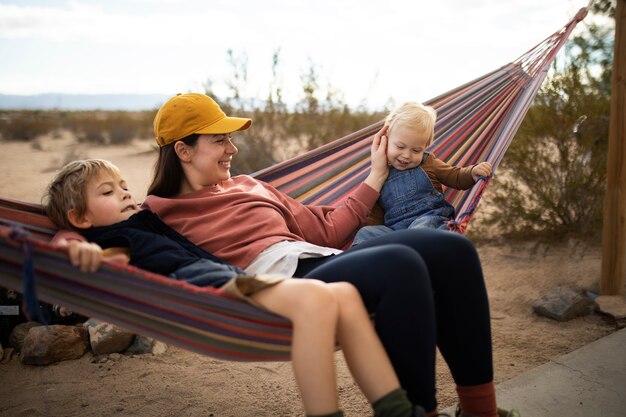 Free photo full shot woman and children on hammock