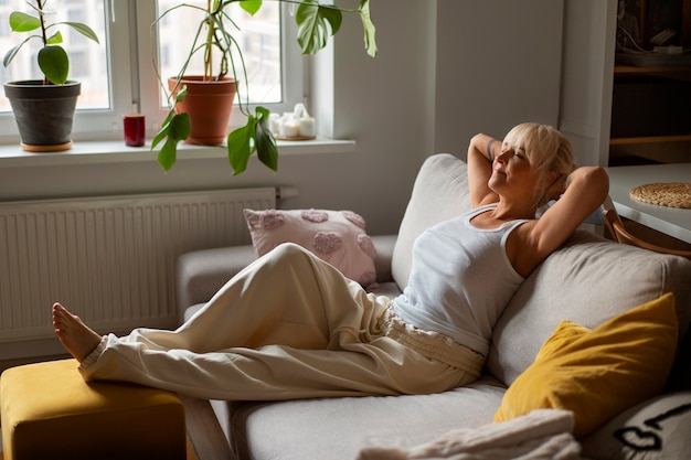 Foto gratuita donna a tutto campo che si rilassa a casa