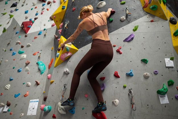 Full shot woman climbing wall