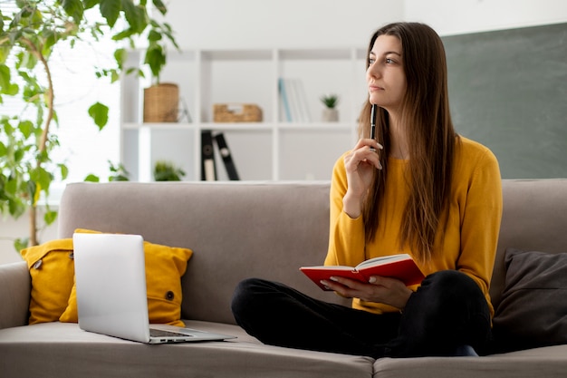 Full shot woman on couch thinking